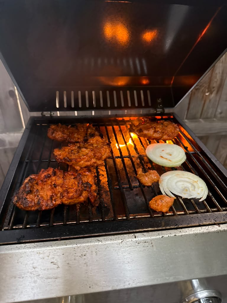 The tandoor lit, coals glowing under the skewers